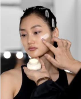 女性在塗抹妝前乳霜。